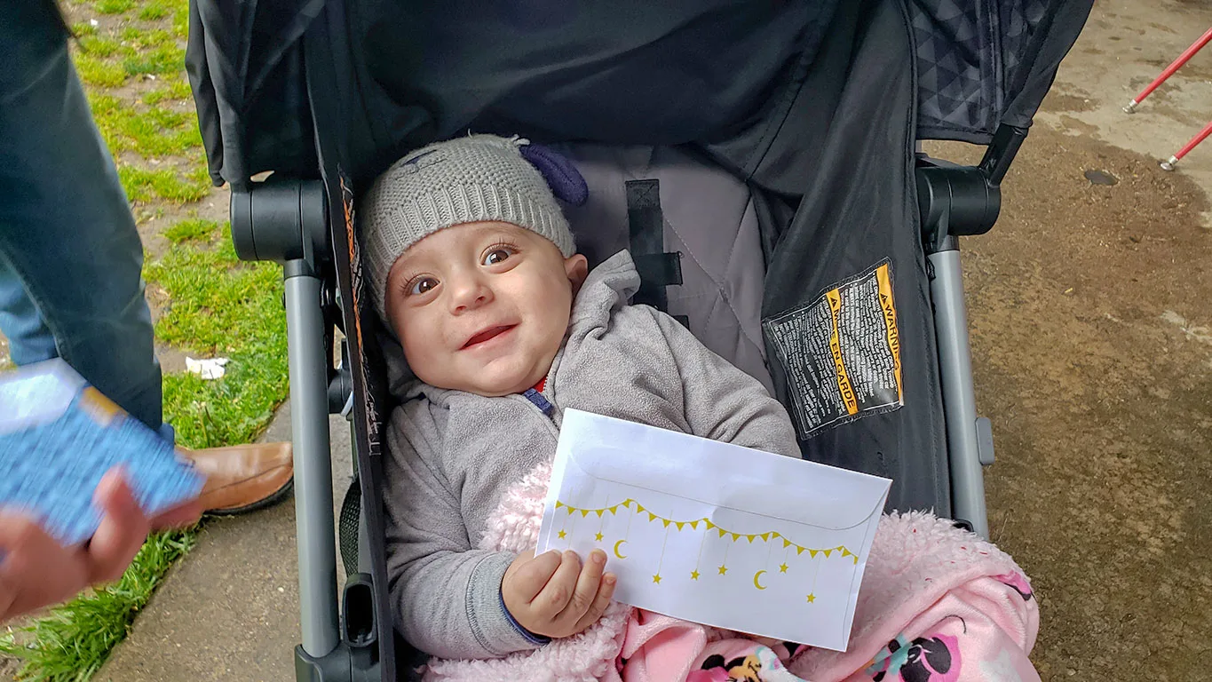 A refugee child smiling after receiving an Eid gift