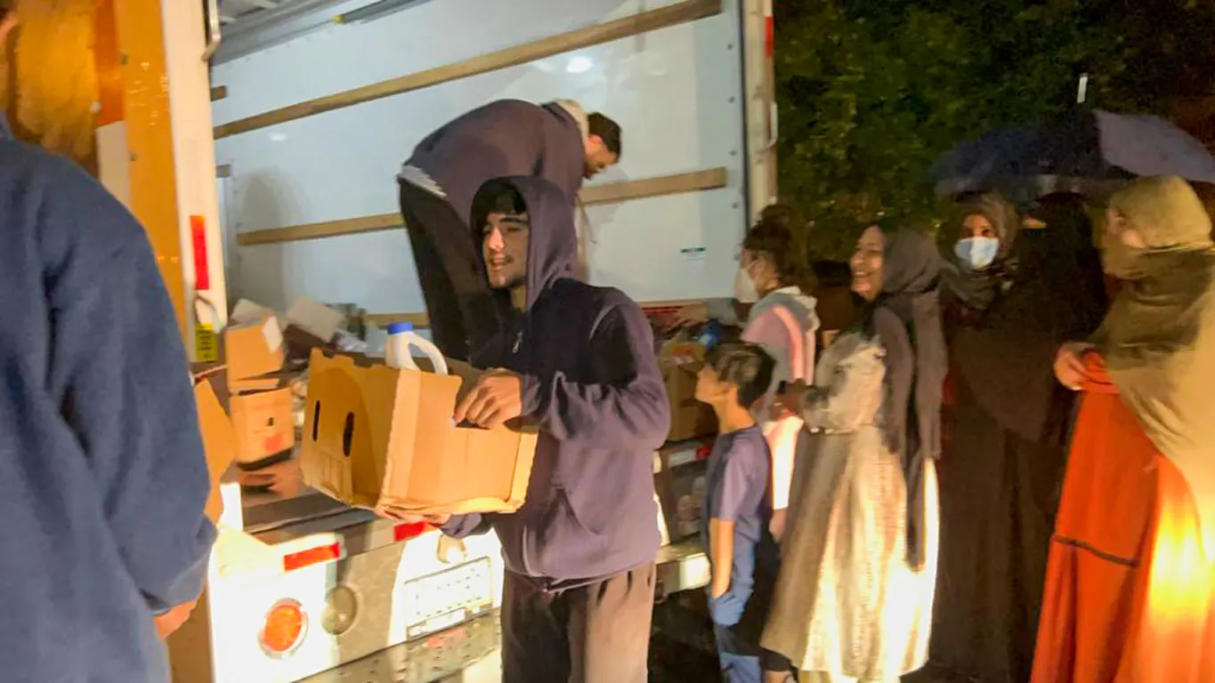 Refugees lined up to receive food packages from Global Shout team
